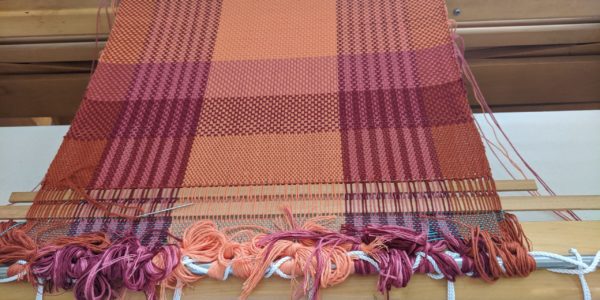 Multi-coloured placemat in progress on loom